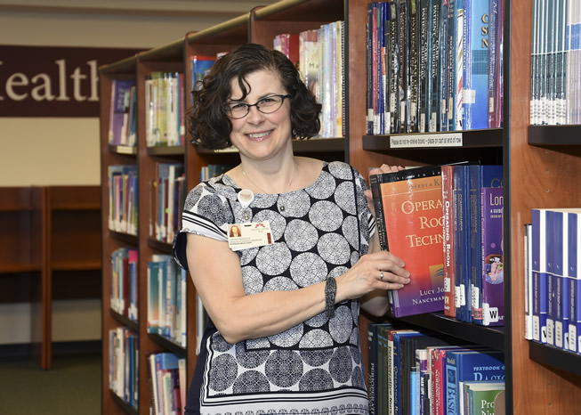 Librarian Noreen Mulcahy selects a book from the Nursing Collection.